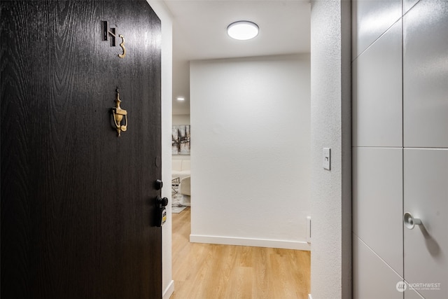 corridor with light hardwood / wood-style floors