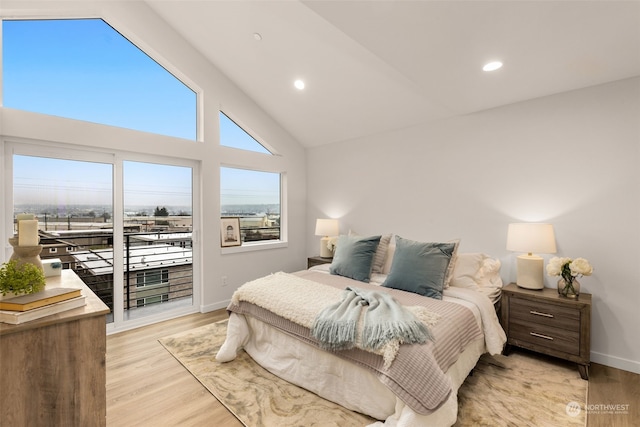 bedroom featuring access to outside, light hardwood / wood-style floors, and high vaulted ceiling