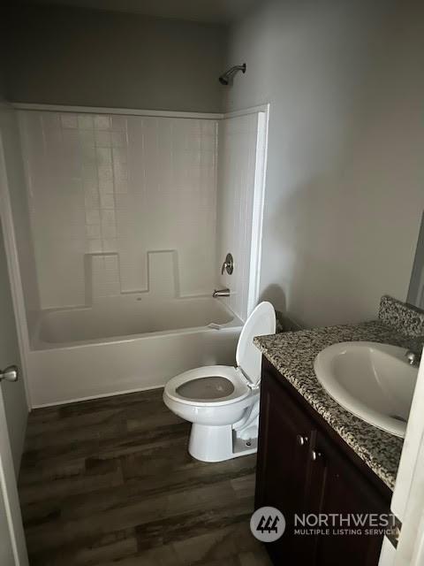 full bathroom with vanity, hardwood / wood-style flooring, toilet, and tub / shower combination