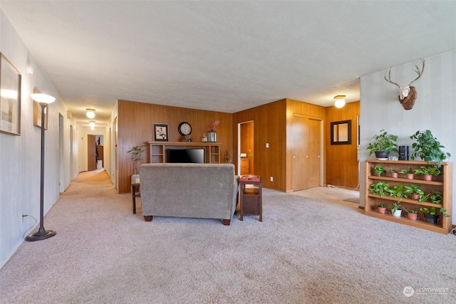 carpeted living room featuring wood walls