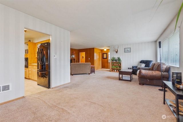 living room with light colored carpet and wood walls