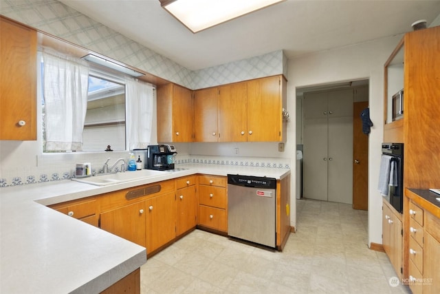 kitchen featuring black oven, tasteful backsplash, stainless steel dishwasher, and sink