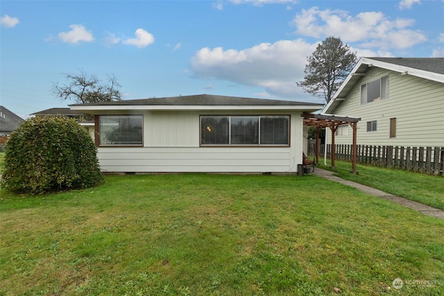 rear view of house featuring a pergola and a yard