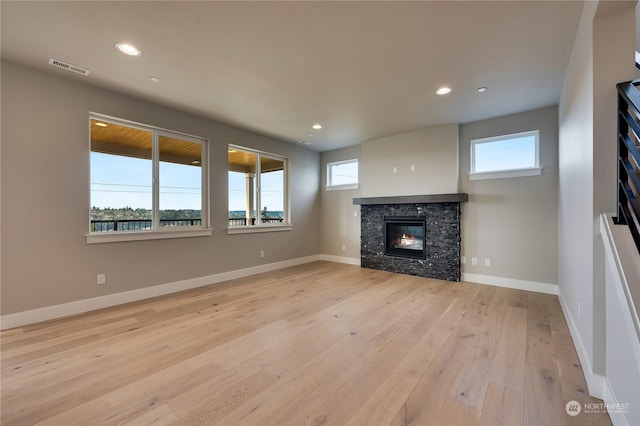 unfurnished living room featuring a fireplace and light hardwood / wood-style floors