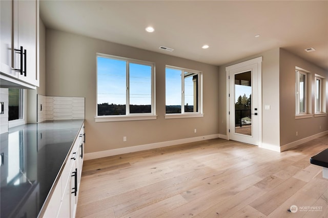 interior space with white cabinets and light hardwood / wood-style flooring