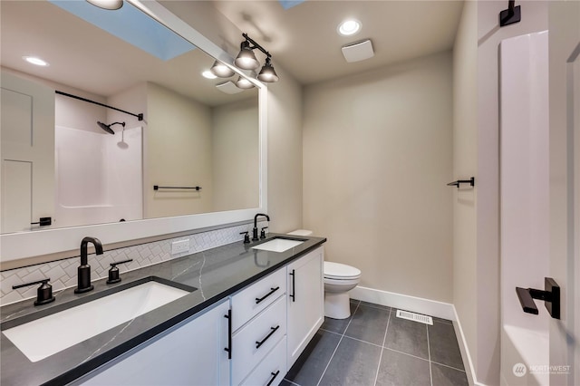 bathroom with vanity, a shower, decorative backsplash, tile patterned floors, and toilet