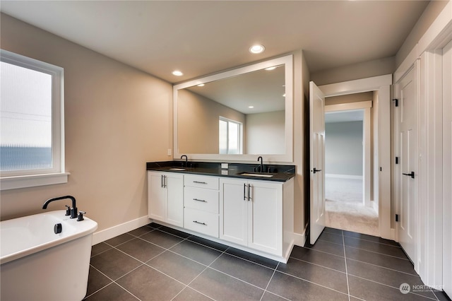 bathroom with vanity, a washtub, and tile patterned floors