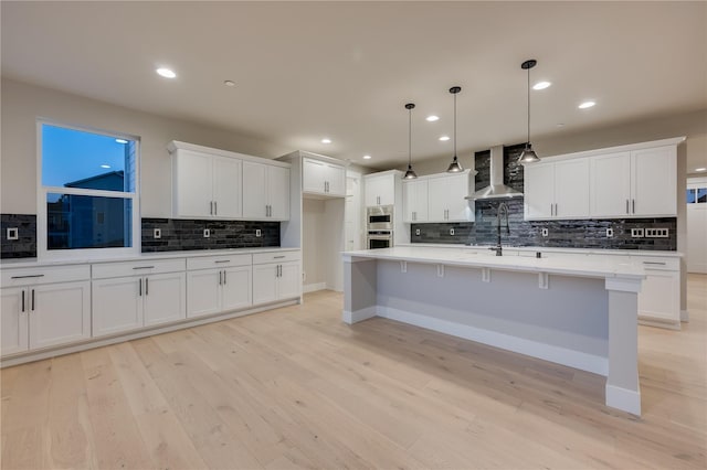 20239 125th Ave NE Unit Sm2-11, Bothell, WA 98011 - kitchen featuring decorative backsplash, light wood-style flooring, wall chimney exhaust hood, and white cabinetry