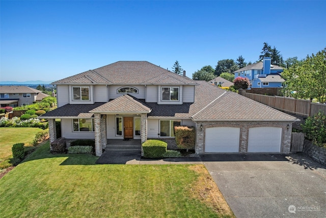 traditional-style home with a garage, asphalt driveway, covered porch, and roof with shingles