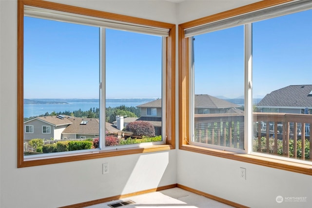 unfurnished sunroom featuring a water view