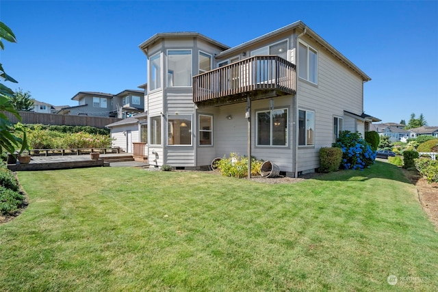 rear view of house featuring a deck, a sunroom, and a yard