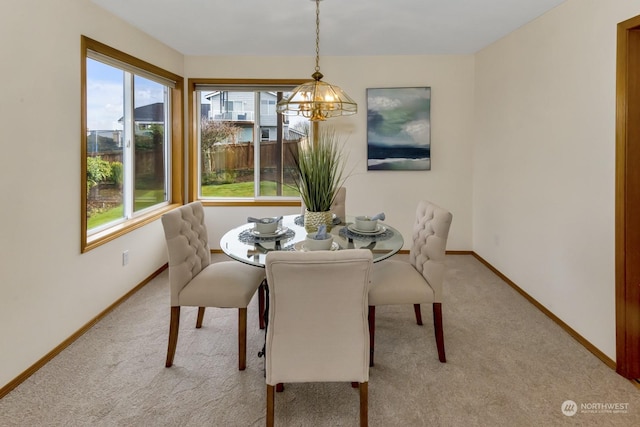 carpeted dining room featuring a chandelier