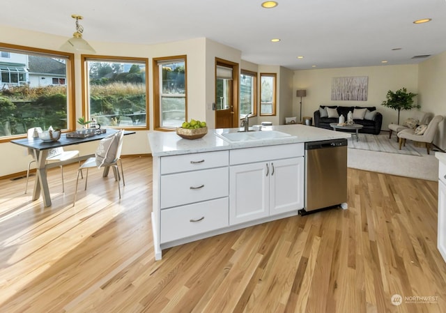 kitchen with white cabinetry, dishwasher, a center island with sink, and sink