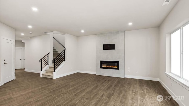 unfurnished living room featuring dark hardwood / wood-style flooring and a fireplace