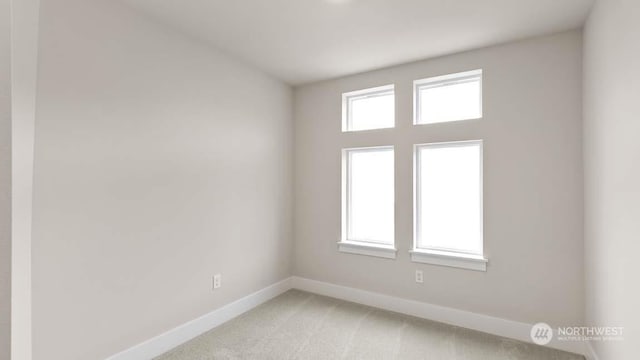 unfurnished room with plenty of natural light and light carpet