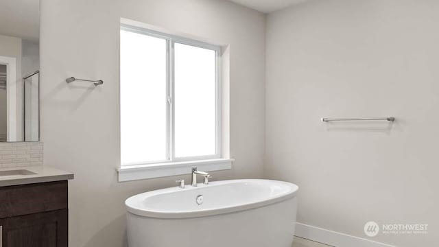 bathroom with decorative backsplash, a bath, and vanity