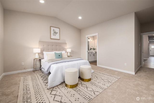 bedroom with carpet, ensuite bathroom, and vaulted ceiling