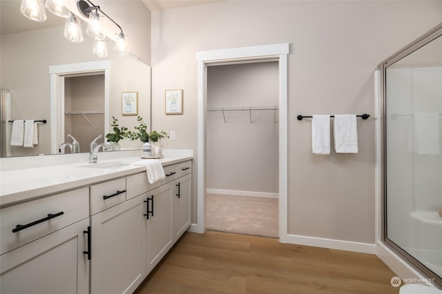 bathroom with vanity, wood-type flooring, and a shower with door