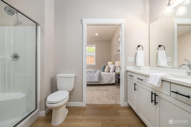 bathroom featuring vanity, toilet, wood-type flooring, and walk in shower