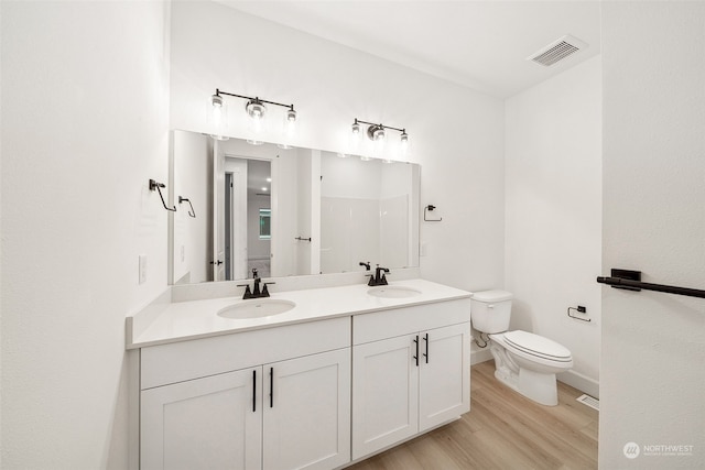 bathroom featuring vanity, toilet, and wood-type flooring