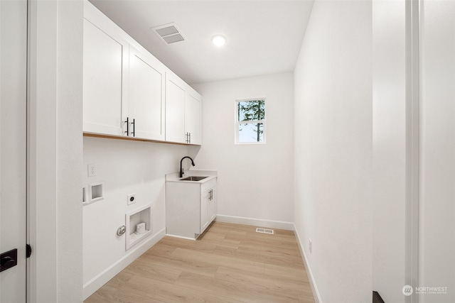 clothes washing area featuring hookup for an electric dryer, hookup for a washing machine, cabinets, sink, and light hardwood / wood-style flooring