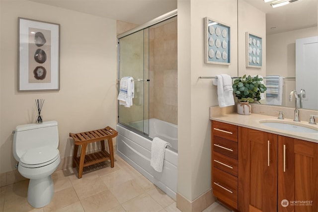 full bathroom featuring vanity, shower / bath combination with glass door, tile patterned floors, and toilet