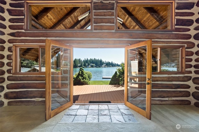 entryway featuring carpet, french doors, a water view, and high vaulted ceiling