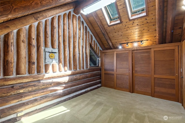 interior space featuring vaulted ceiling with skylight, carpet, and wooden ceiling