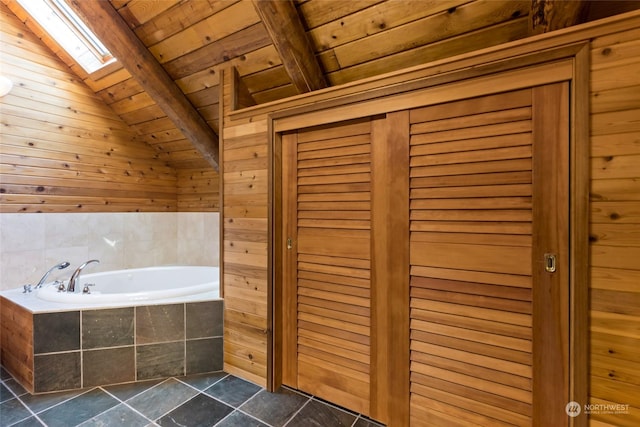 bathroom with tiled bath, lofted ceiling with skylight, wooden ceiling, and wood walls