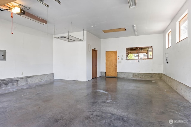 garage featuring electric panel and a garage door opener