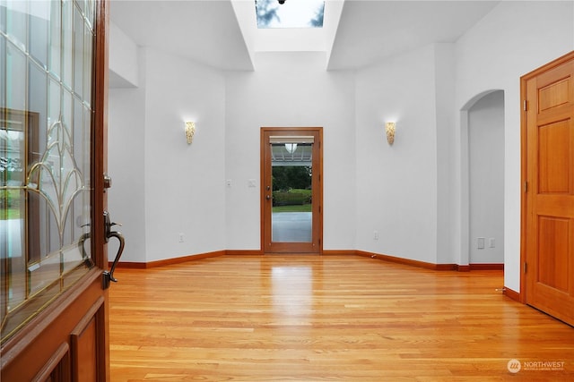 interior space with a skylight and light hardwood / wood-style floors