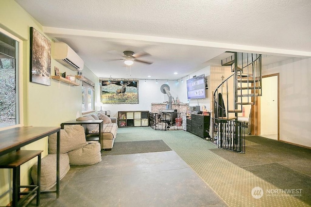 carpeted living room with a wall mounted air conditioner, a textured ceiling, a wood stove, and ceiling fan