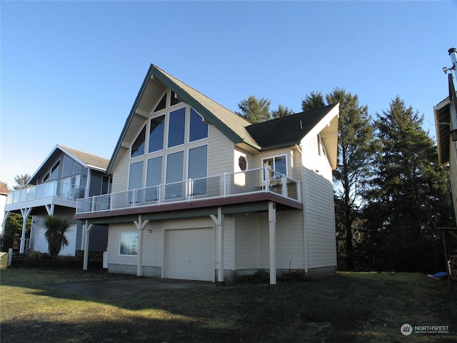 back of property with a yard, a balcony, and a garage