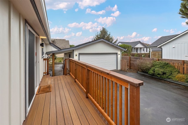 wooden terrace with a garage and an outbuilding