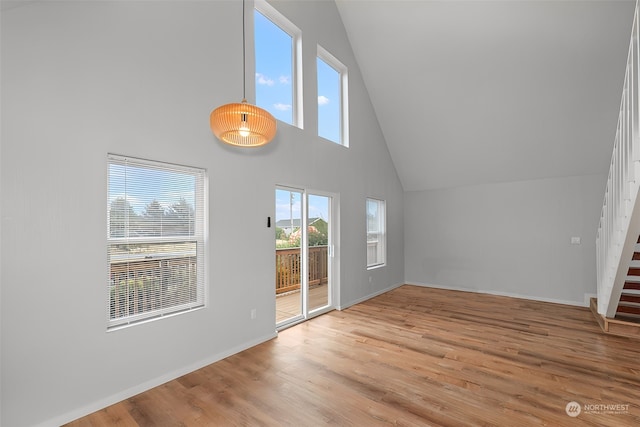 interior space with a towering ceiling and light hardwood / wood-style flooring