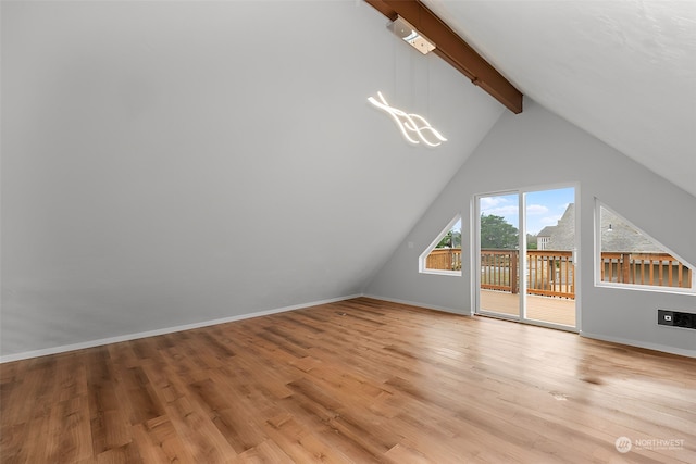 additional living space featuring vaulted ceiling with beams and light wood-type flooring