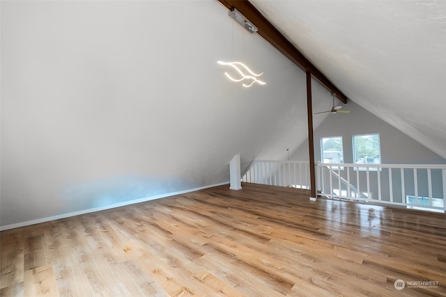 additional living space featuring lofted ceiling with beams, light hardwood / wood-style floors, and ceiling fan