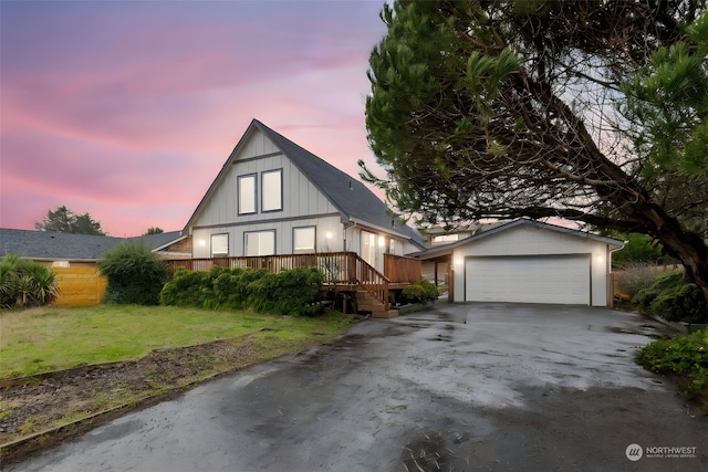 view of front of property with a garage, a yard, and a deck