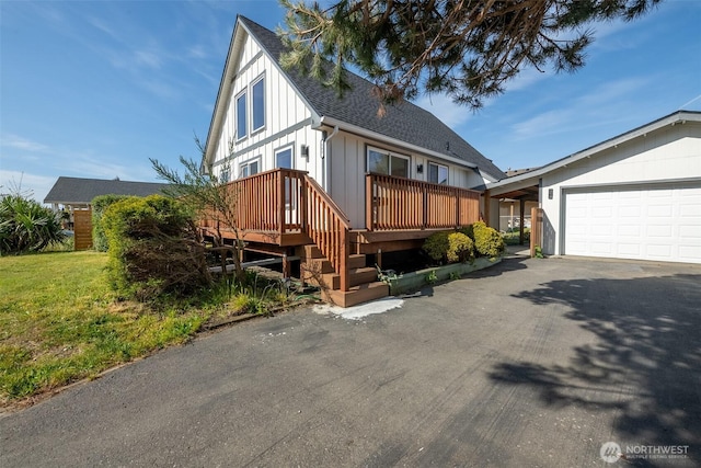 585 Ocean Shores Blvd SW, Ocean Shores, WA 98569 - view of front of house featuring a garage, asphalt driveway, a shingled roof, and board and batten siding
