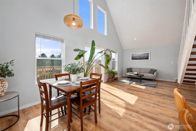 585 Ocean Shores Blvd SW, Ocean Shores, WA 98569 - dining room with high vaulted ceiling, stairway, light wood finished floors, and baseboards