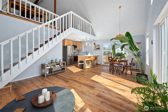 585 Ocean Shores Blvd SW, Ocean Shores, WA 98569 - living room with high vaulted ceiling, stairs, light wood finished floors, and baseboards