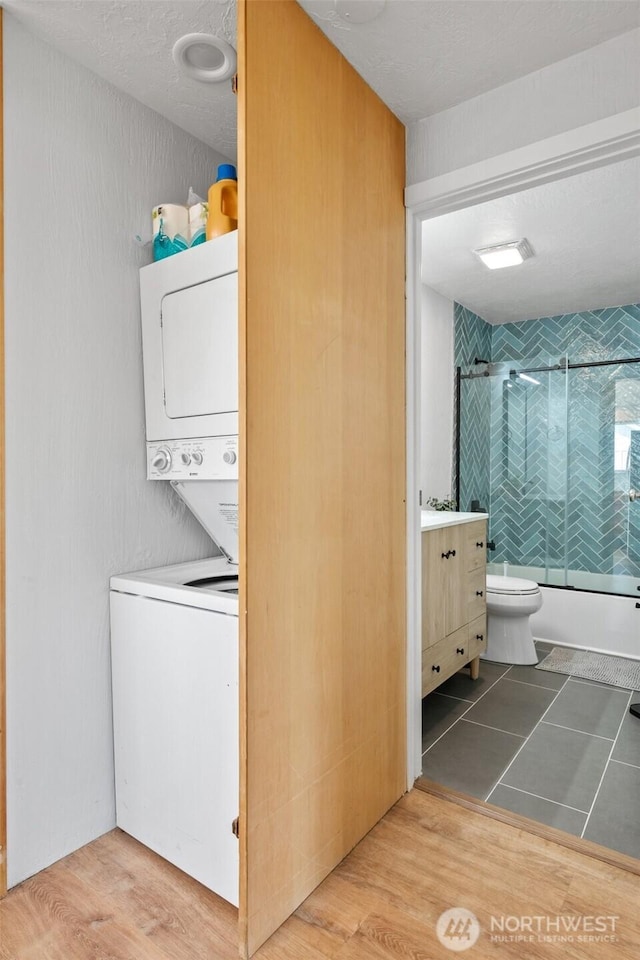 585 Ocean Shores Blvd SW, Ocean Shores, WA 98569 - laundry area featuring stacked washing machine and dryer and wood finished floors