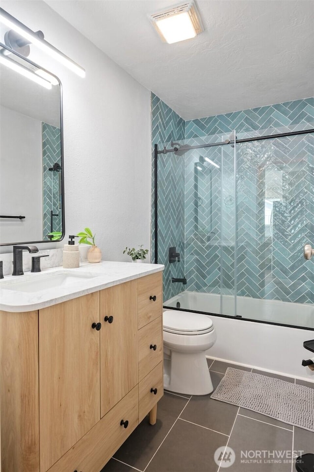 585 Ocean Shores Blvd SW, Ocean Shores, WA 98569 - bathroom featuring shower / bath combination with glass door, vanity, toilet, and tile patterned floors