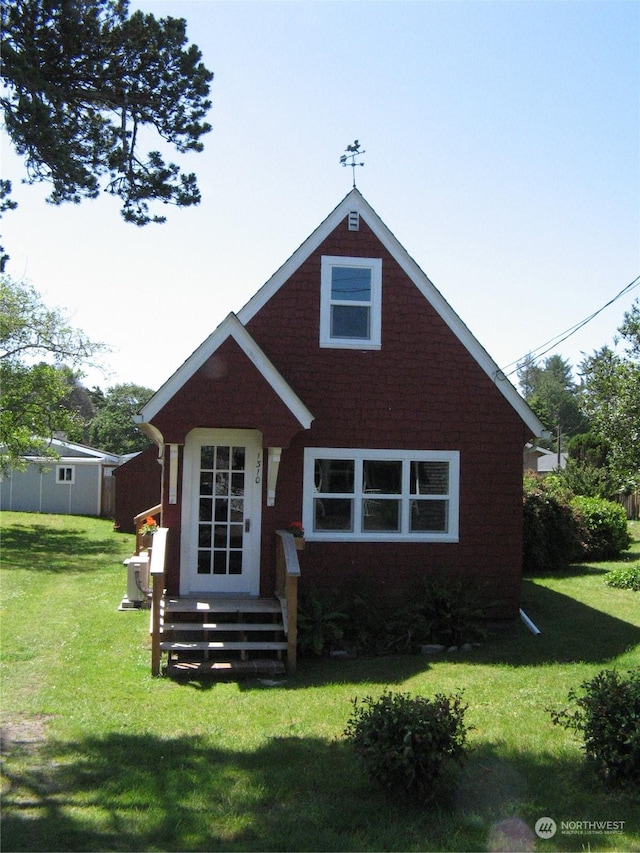 rear view of property featuring a lawn