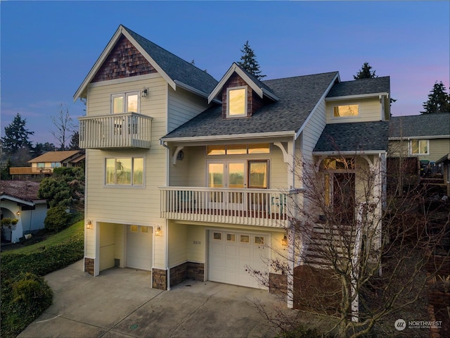 view of front of property featuring a balcony and a garage