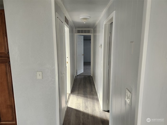 corridor featuring dark hardwood / wood-style flooring and crown molding