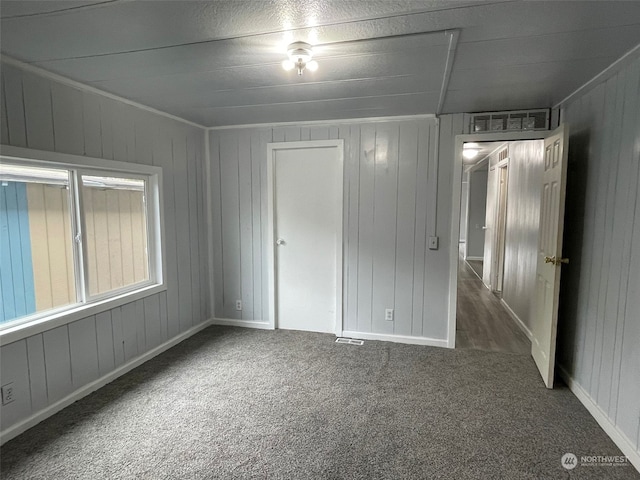 unfurnished bedroom with dark colored carpet