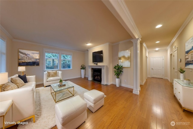 living room featuring decorative columns, crown molding, and light hardwood / wood-style floors