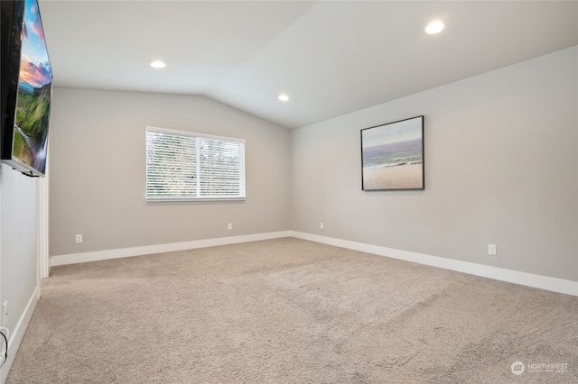 empty room with lofted ceiling and light carpet