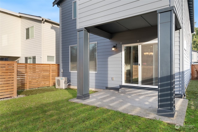 rear view of house with a patio, ac unit, and a lawn